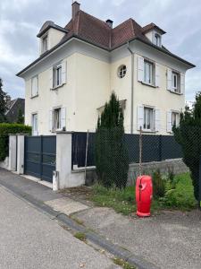 a red suitcase sitting in front of a house at Chez F & G in Sélestat
