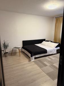 a bedroom with a large bed and a table at Apartament Densia in Craiova close to the center in Craiova