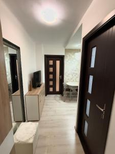 a hallway with a door and a room with a table at Apartament Densia in Craiova close to the center in Craiova