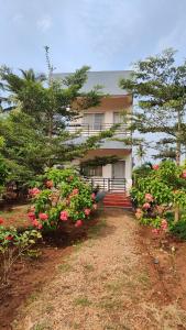 Serene Homestay في بادامي: منزل أمامه زهور وردية