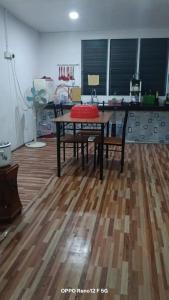 una habitación con una mesa con un cojín rojo sobre un suelo de madera en Qmar D Sepang, en Sepang