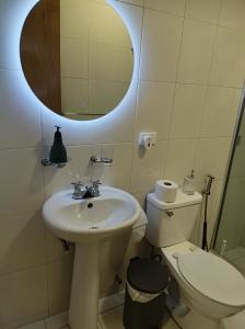 a bathroom with a sink and a toilet and a mirror at Apartamento Amplio Cerca de Todo con Seguridad y con Todas las Comodidades de un Hospedaje Renovado y Totalmente Equipado, ademas Tene Wi-Fi de Alta Velocidad in Caracas