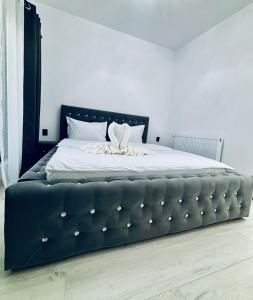 a bedroom with a large bed with a black headboard at Secret Forest Avrig By Erwin in Avrig