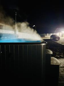 un jacuzzi del que sale vapor por la noche en Secret Forest Avrig By Erwin, en Avrig