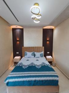 Un dormitorio con una cama y dos mesitas de noche. en Appartements meublés à louer à Jebha avec une charmante vue sur la mer, en Yebha