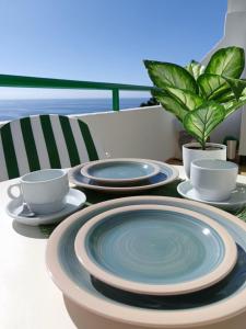 Vista Paraíso Puerto Rico في بورتو ريكو: طاولة بها أطباق وأكواب زرقاء وبيضاء