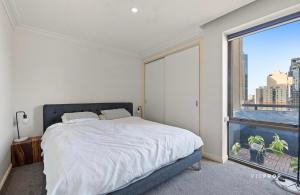 una camera da letto con un letto e una grande finestra di Penthouse Retreat in Heart ofCBD a Melbourne Altre 6 foto