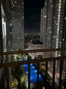 - un balcon offrant une vue sur la ville la nuit dans l'établissement The Majestic Staycation, à Manille
