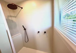 a bathroom with a shower with two knobs on the wall at Top of Tyne - Peace, Comfort & Local Connection in Oamaru +8 photos