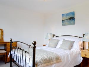 a bedroom with a bed and a desk with two lamps at Lunga - 28791 in Clachan +4 photos