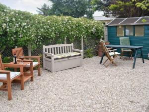 a patio with chairs and a table and a bench at Anchorage in Maidens +2 photos