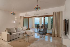 a living room with a couch and a tv at Wateera Jebel Sifah in As Sīfah