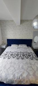 Un dormitorio con una cama con cabecero azul. en Apartman Vaske 2, en Brčko