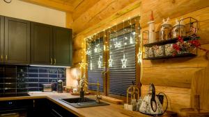 a kitchen with wooden cabinets and a sink and a window at Chata Czego Dusza Pragnie in Zachełmie