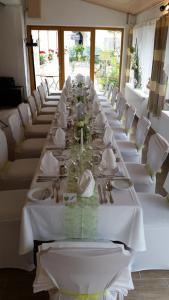 einen langen Tisch mit weißen Tischen und weißen Stühlen in der Unterkunft Gasthof Pflamminger in Wörth an der Donau