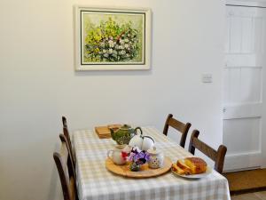 een tafel met een bord eten en een schilderij aan de muur bij Dylasau Cottage in Capel Garmon