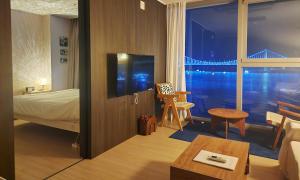 a hotel room with a bed and a large window at an emotional view of the sea at sunrise in Kwangan-dong