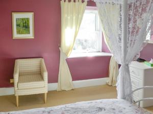 a bedroom with a bed and a window and a chair at Oak Cottage-16498 in Catcleugh