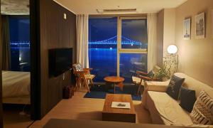 a living room with a couch and a view of a bridge at an emotional view of the sea at sunrise in Kwangan-dong