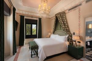 a bedroom with a white bed and a chandelier at Hotel Alfonso XIII, a Luxury Collection Hotel, Seville in Seville