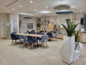 a conference room with a table and blue chairs at DOMITYS - La Via Domitia in Gap