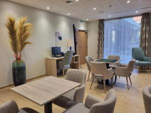 a waiting room with chairs and tables and a desk at DOMITYS - La Via Domitia in Gap +2 photos