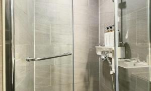 a shower with a glass door next to a sink at an emotional view of the sea at sunrise in Kwangan-dong +44 photos