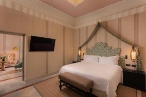 a bedroom with a large bed and a tv at Hotel Alfonso XIII, a Luxury Collection Hotel, Seville in Seville