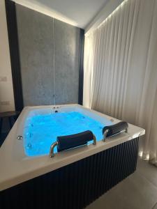 a bath tub with blue water in a room at חוויה בכיכר in Netanya
