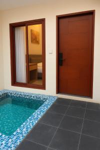 a room with a swimming pool next to a door at villa koku kuta in Legian