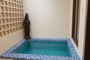 a small swimming pool in a room with a statue at villa koku kuta in Legian
