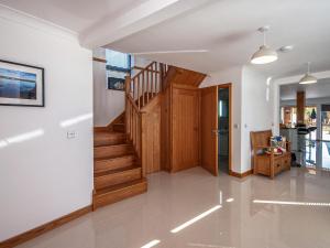 un pasillo con una escalera de madera en una casa en Parrog Point, en Newport 19 fotos más