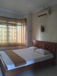 a large bed in a bedroom with a window at Duta Kencana in Timuran