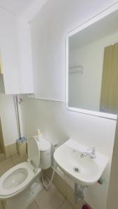 a bathroom with a white toilet and a sink at Resort Condo in Trece Martires Cavite in Trece Martires