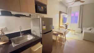 a kitchen with a stainless steel refrigerator and a table at Resort Condo in Trece Martires Cavite in Trece Martires