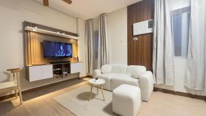 a living room with a white couch and a tv at Resort Condo in Trece Martires Cavite in Trece Martires