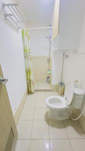 a bathroom with a white toilet in a room at Resort Condo in Trece Martires Cavite in Trece Martires