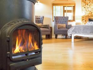 a fireplace in a living room with a fire at Bensfield Treehouse in Wadhurst