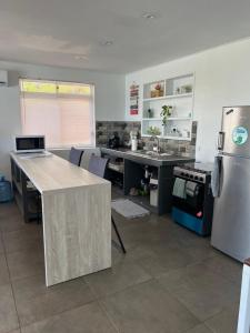 a kitchen with a table and a refrigerator in it at Blue Essence Tahaa in Tahaa