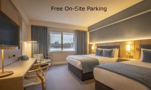 a hotel room with two beds and a desk at Lancaster Lodge in Cork