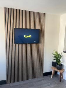 a flat screen tv on a wooden wall at Mint Cottage - pet friendly house in Kendal in Kendal