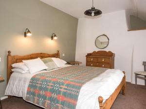 ein Schlafzimmer mit einem Bett, einer Kommode und einem Spiegel in der Unterkunft Bwlchgroes in Dinas