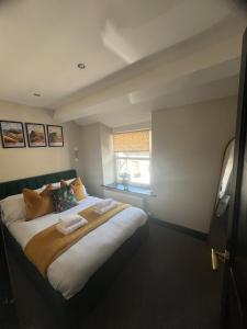 a large bed in a room with a window at Mint Cottage - pet friendly house in Kendal in Kendal