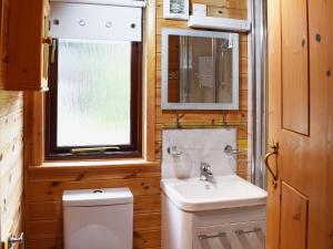 a bathroom with a sink and a toilet and a window at Ashness in Keswick +2 photos