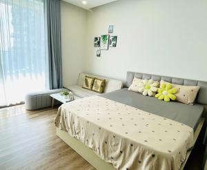 a bedroom with a bed with yellow flowers on it at Ecopark Homestay - Căn hộ studio, 1 ngủ, 2 ngủ, 3 ngủ - Bể bơi, phòng gym, tắm khoáng Onsen in Kim Quan