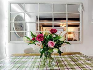 a vase filled with roses sitting on a table at Wellside Cottage in Starbotton