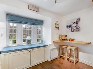 a kitchen with white cabinets and a blue counter top at Wellside Cottage in Starbotton +10 photos