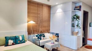 a bedroom with a bed and a couch and a table at Ecopark Homestay - Căn hộ studio, 1 ngủ, 2 ngủ, 3 ngủ - Bể bơi, phòng gym, tắm khoáng Onsen in Kim Quan