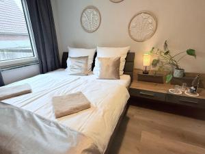 a bedroom with a large white bed with a window at Wilhelmines Hafenliebe am Park mit Balkon, Netflix, & Privatparkplatz in Wilhelmshaven