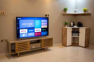 ジッダにあるMira AlSafaの木製エンターテイメントセンターに座って薄型テレビを視聴できます。